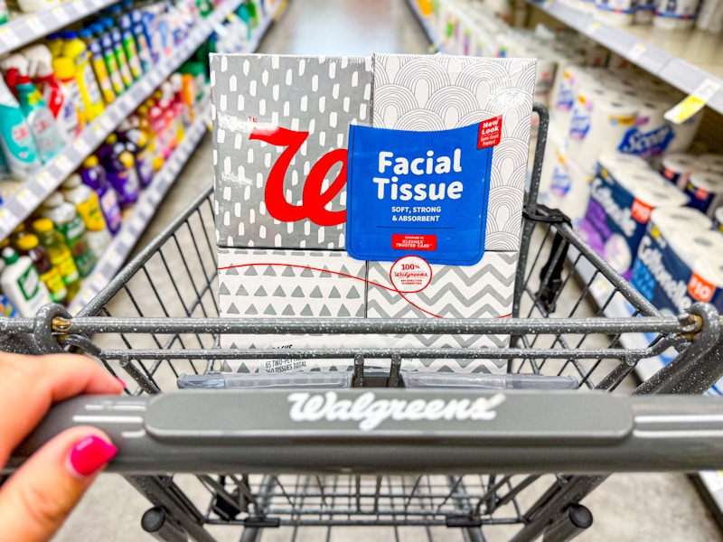 person pushing a cart with a 4-pack of facial tissues in it