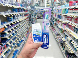 hand holding crest and oral-b in walgreens