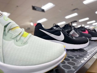 A variety of Nike shoes sitting on a store shelf.