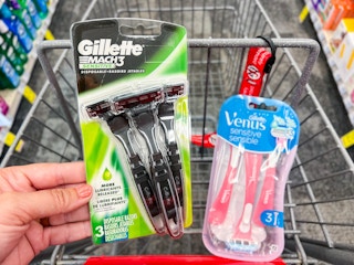 hand holding pack of Gillette Mach3 razors and Gillette Venus Sensitive razors in front of shopping cart