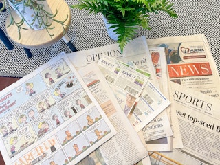 multiple newspapers spread out