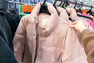 person grabbing a pink puffer jacket