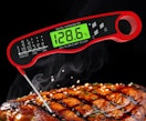 a red digital thermometer in a steak