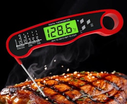 a red digital thermometer in a steak