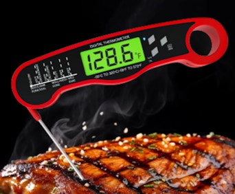 a red digital thermometer in a steak