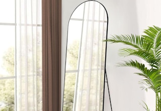 arched bedroom mirror next to window