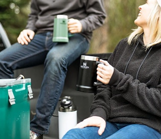 People holding a beer stein outdoors