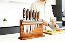 knives on a wooden magnetic holder on a kitchen counter