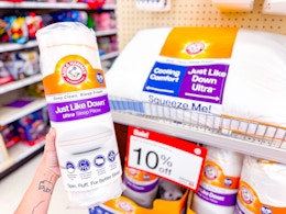hand holding an arm & hammer down pillow in front of a target shelf