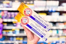 hand holding two boxes of Arm & Hammer Complete Care toothpaste