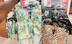 someone holding up a swimsuit in the swimwear section in jcpenney