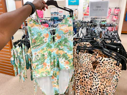 someone holding up a swimsuit in the swimwear section in jcpenney