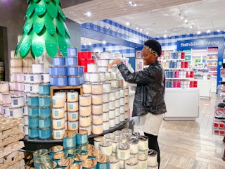 A woman looking at candles at Bath and Body works