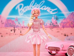 a barbie the movie doll in front of a pink car