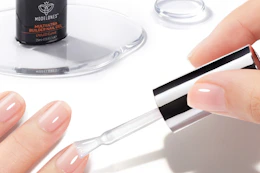 a woman painting her nails clear