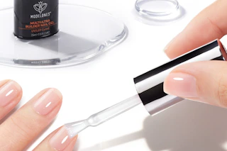 a woman painting her nails clear