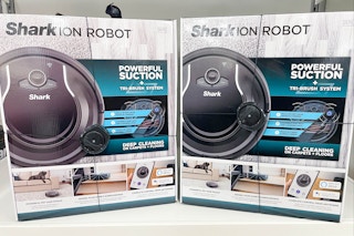 Two Shark Ion Robot floor vacuums stocked on a shelf inside Kohl's.