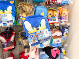 hand holding a character hooded bath towel in front of target shelf