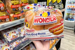hand holding a package of wonder hot dog buns