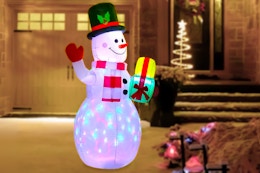 Lifestyle image of the Belita Amu Snowman Christmas Inflatable set up outdoors in front of a house