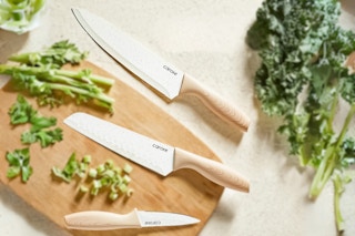 Lifestyle image of Carote 12-Piece Knife Set used in kitchen setting (veggies + cutting board)