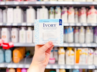 hand holding a 4-count of Ivory bar soap