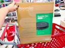 roomba robot vacuum sitting on top of a target cart