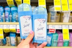 person holding 2 secret deodorants in front of a shelf