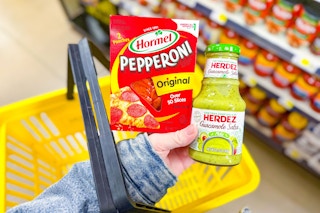 hand holding hormel and herdez above yellow shopping basket