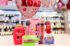ogx shampoo, maybelline mascara, real techniques makeup brush set, chi heat spray, and loreal moisturizer on a shelf with a xoxo balloon