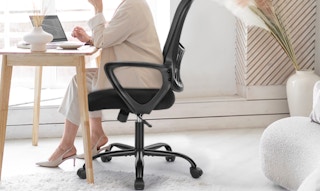 a person sitting in an office chair at a table 