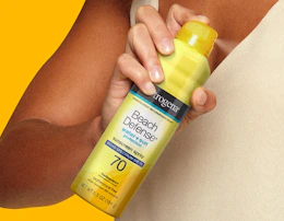a person holding a yellow can of sunscreen