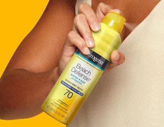 a person holding a yellow can of sunscreen