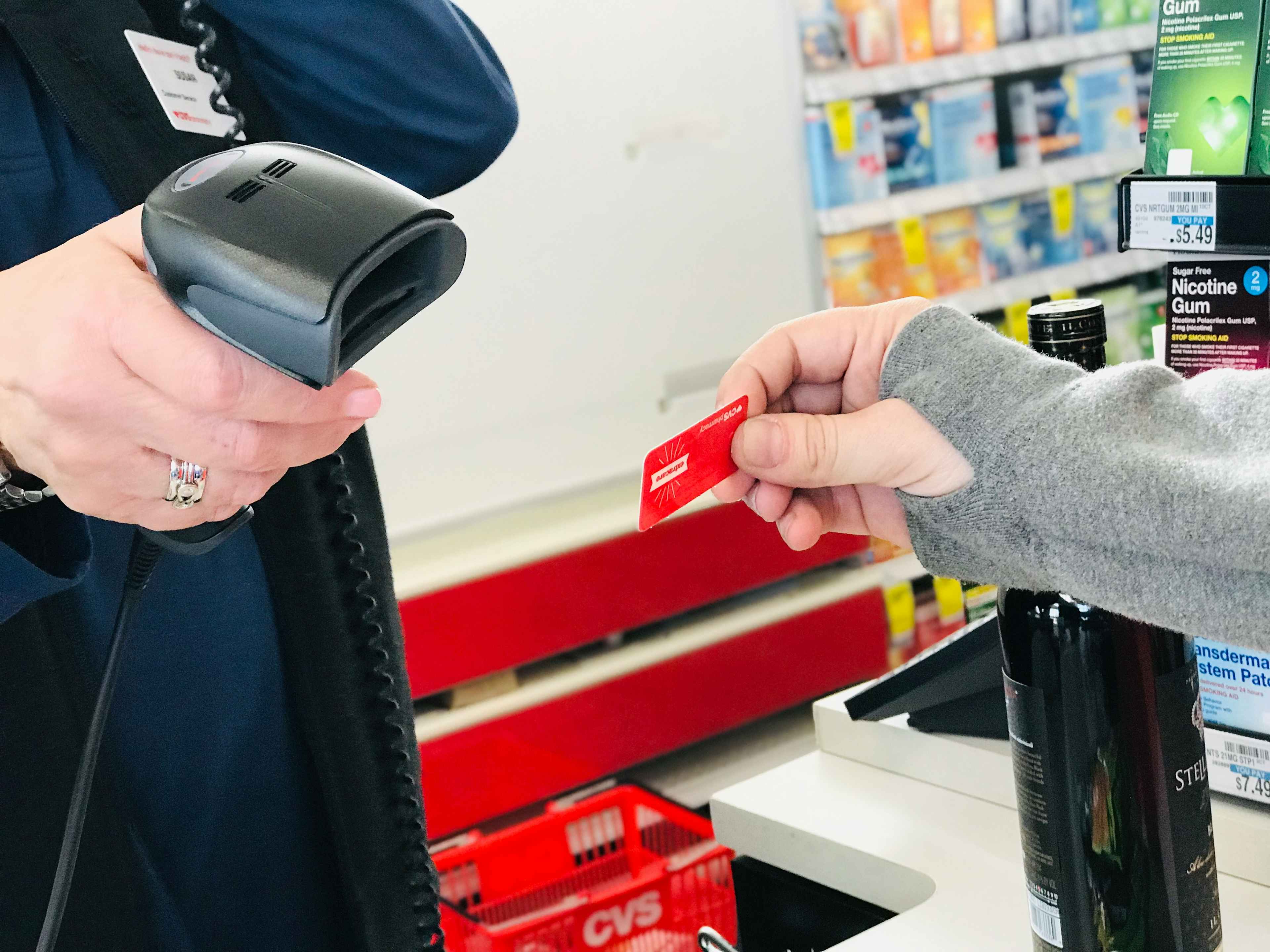A CVS employee scanning a CVS ExtraCare card at checkout