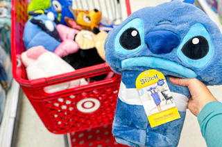 hand holding a Stitch wearable blanket in front of a target cart