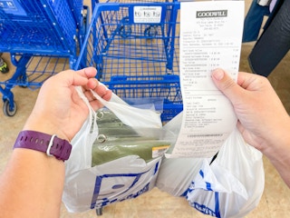 a goodwill receipt being held with shopping bag