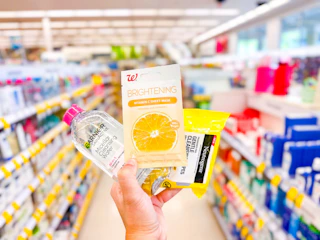 hand holding neutrogena. garnier, and walgreens skin care