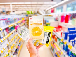 hand holding neutrogena. garnier, and walgreens skin care