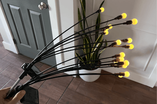 a hand holding firefly garden lights