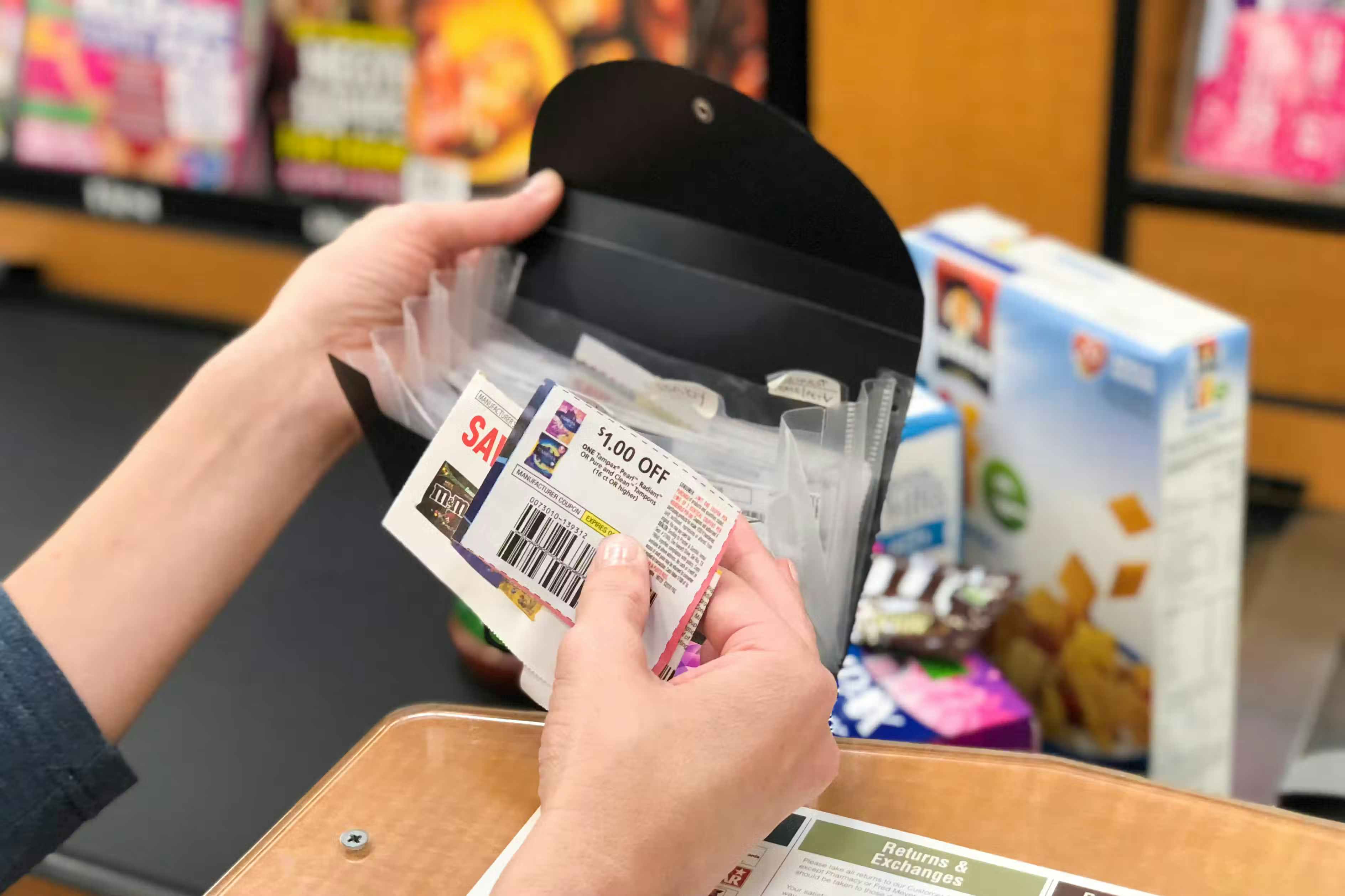 someone taking coupons out of their little folder at checkout