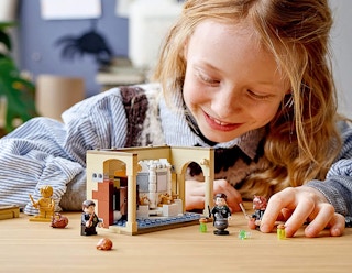 a kid playing with a harry potter lego set