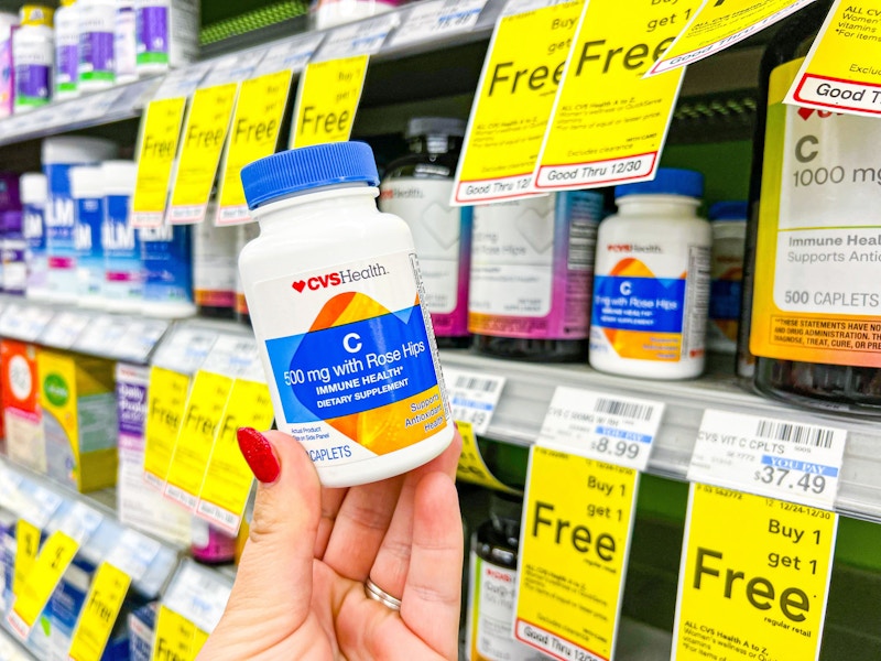 person holding a bottle of vitamin c tablets