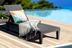Lifestyle image of the Gymax Outdoor Chaise Lounge Chair set up by a pool