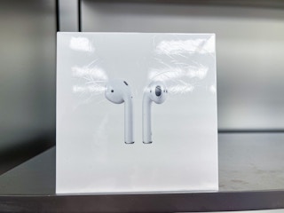 A pair of AirPods sitting on a shelf.
