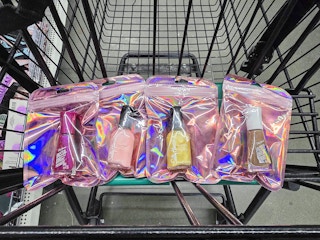 4 bags containing sally hansen nail polish in a cart