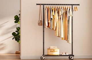 a clothing rack with clothes against the wall