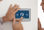 a couple of people using the Honeywell Home Smart Thermostat