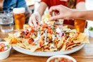 a group of friends eating nachos at a mexican restaurant