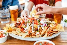 a group of friends eating nachos at a mexican restaurant