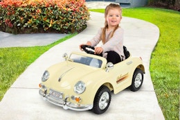 Lifestyle image of the Lil' Rider 6V Kids Ride-On Car used outdoors on a pavement 
